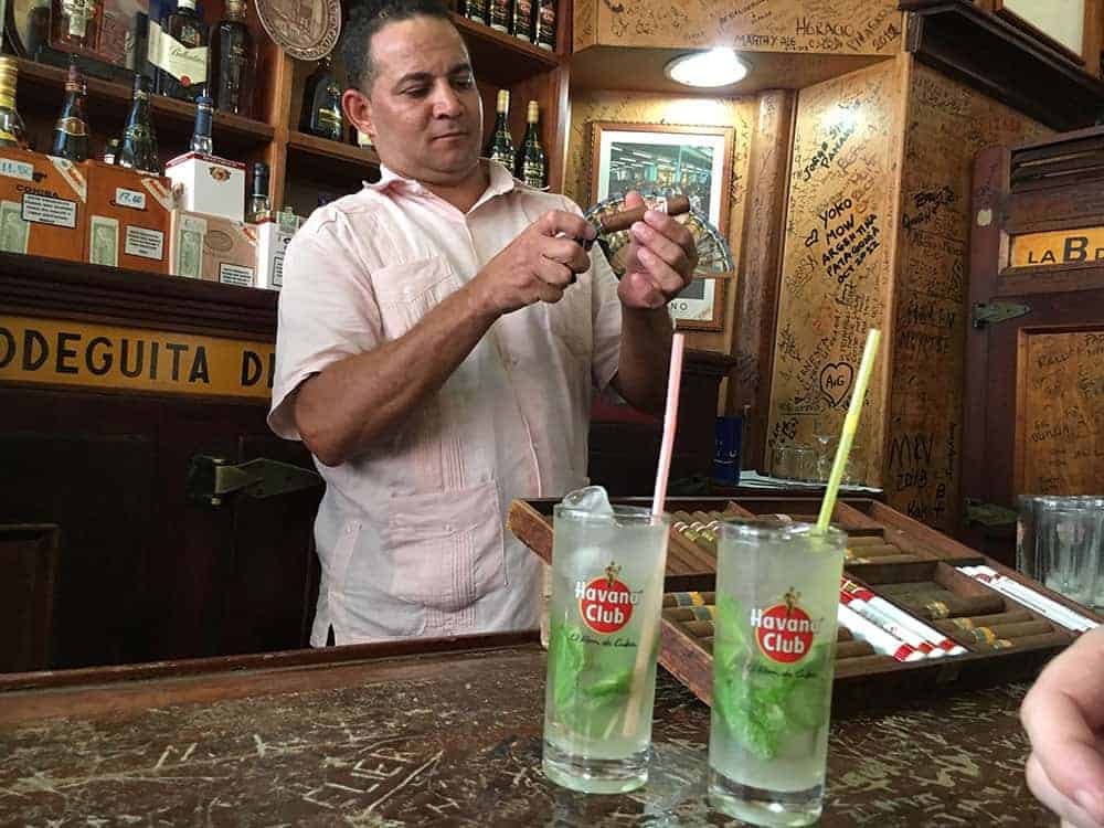 Cigar being lit at La Bodeguita with our mojitos